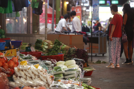 22일 오전 서울의 한 재래시장에서 시민이 장을 보고 있다. 한국은행에 따르면 6월 생산자물가지수(잠정)는 5월보다 0.5% 오른 120.04 (2015년 수준 100)로 집계됐다. 올해 1월 이후 여섯 달 연속 상승세다. <연합뉴스>